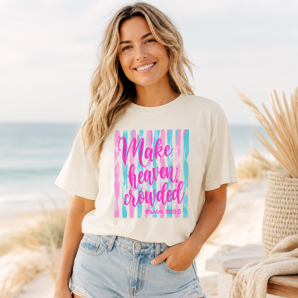 Woman wearing an Ivory Make Heaven Crowded Christian shirt near the beach